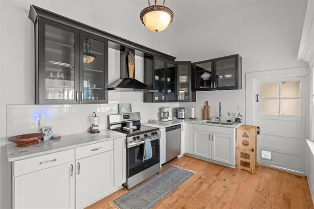 a kitchen with stainless steel appliances granite countertop a stove a sink and a granite counter tops with wooden floors