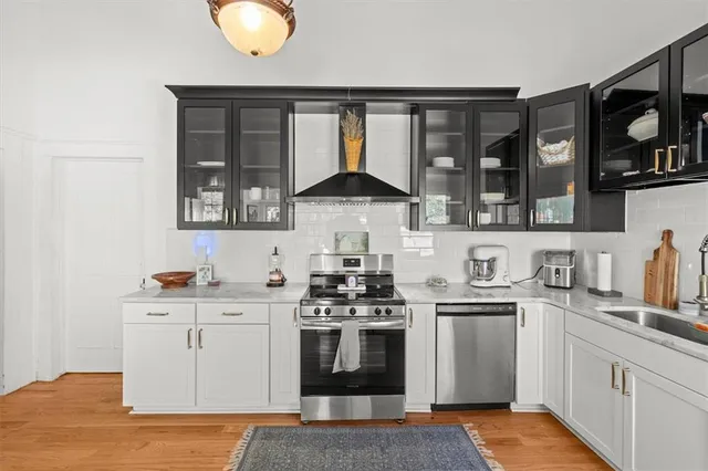 a kitchen with stainless steel appliances a stove a sink and a microwave
