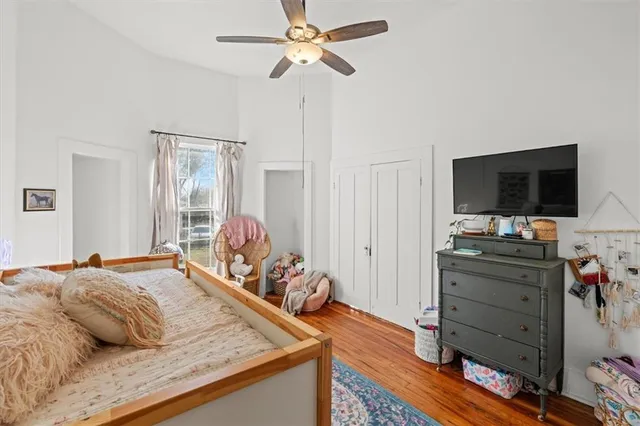a bedroom with a bed and a flat tv screen on dresser