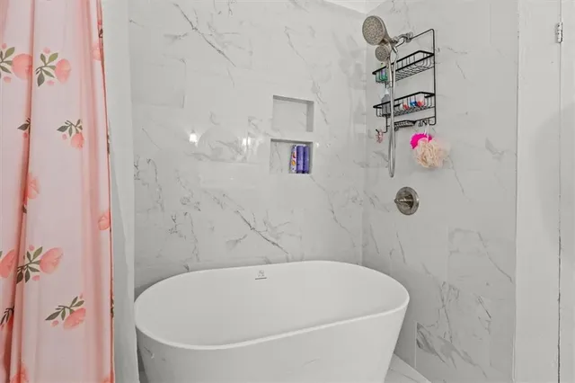 a bathroom with a white bath tub and shower