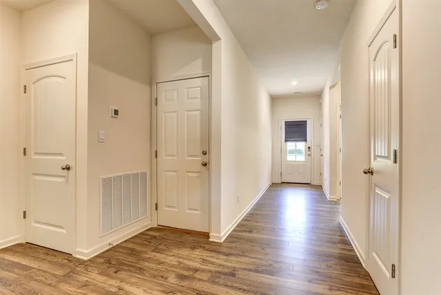 a view of a hallway with wooden floor
