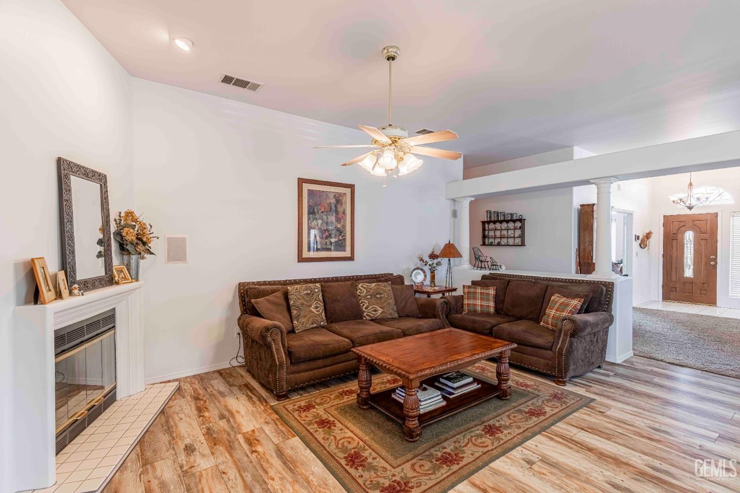 Undisclosed Address Bakersfield, CA 93312 - Photo 13 of 43 a living room with furniture a chandelier and a fireplace