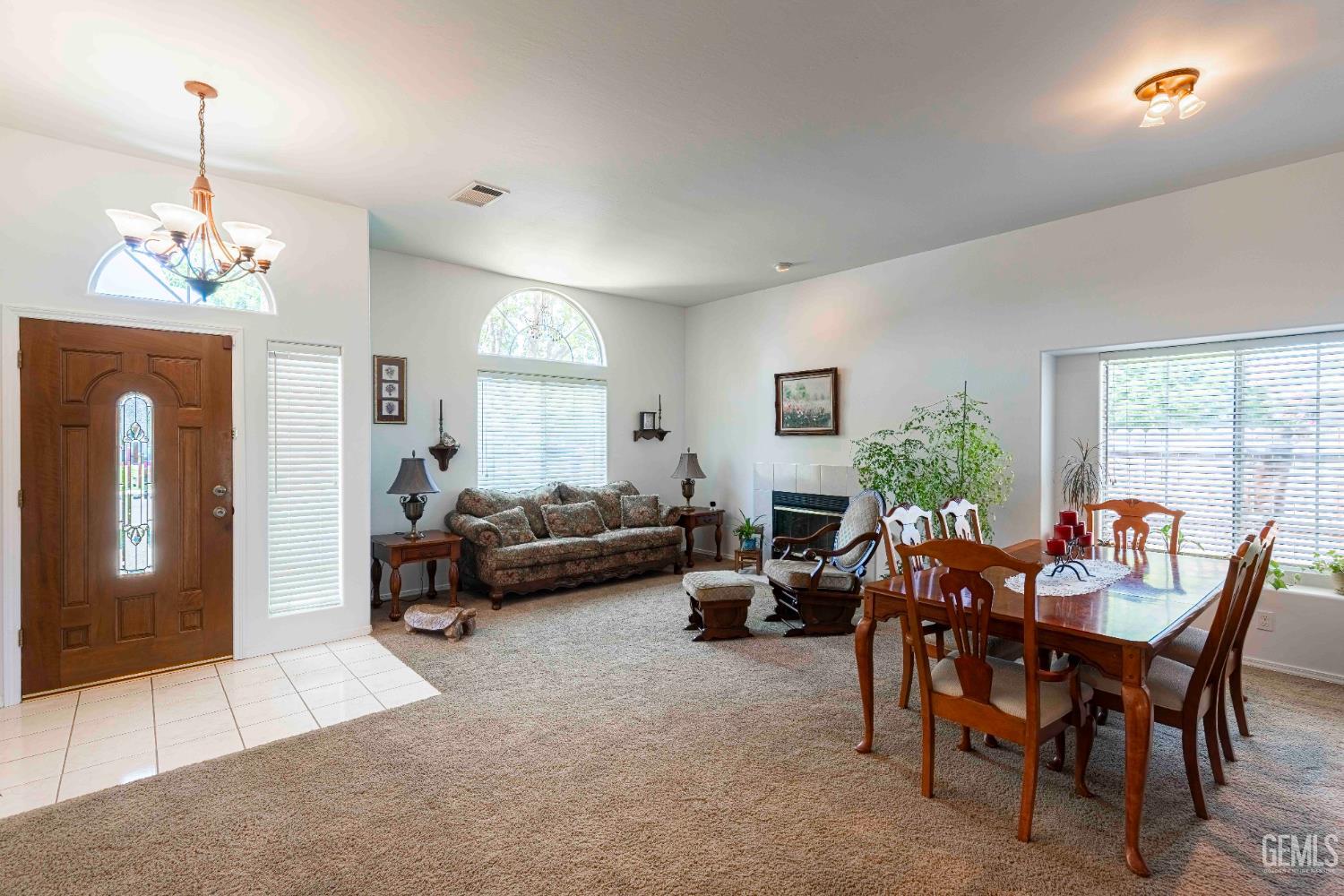 Undisclosed Address Bakersfield, CA 93312 - Photo 16 of 43 a living room with furniture a chandelier and a table