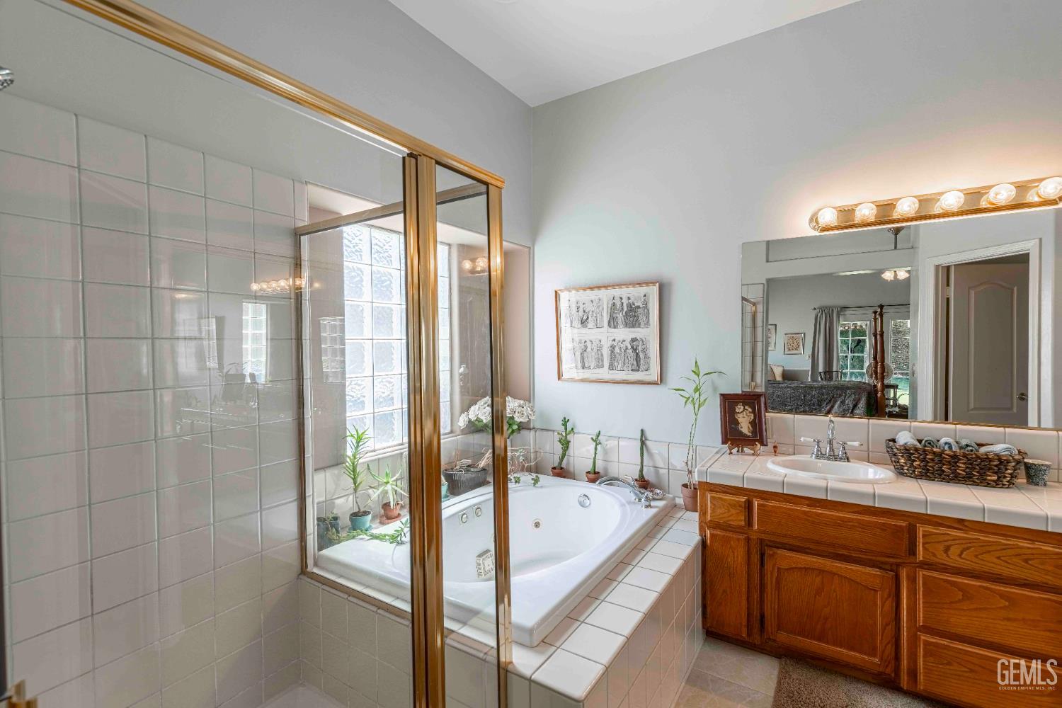 Undisclosed Address Bakersfield, CA 93312 - Photo 26 of 43 a spacious bathroom with a granite countertop tub sink shower and mirror