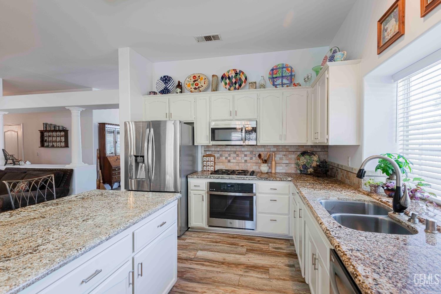 Undisclosed Address Bakersfield, CA 93312 - Photo 8 of 43 a kitchen with granite countertop a sink stainless steel appliances and white cabinets