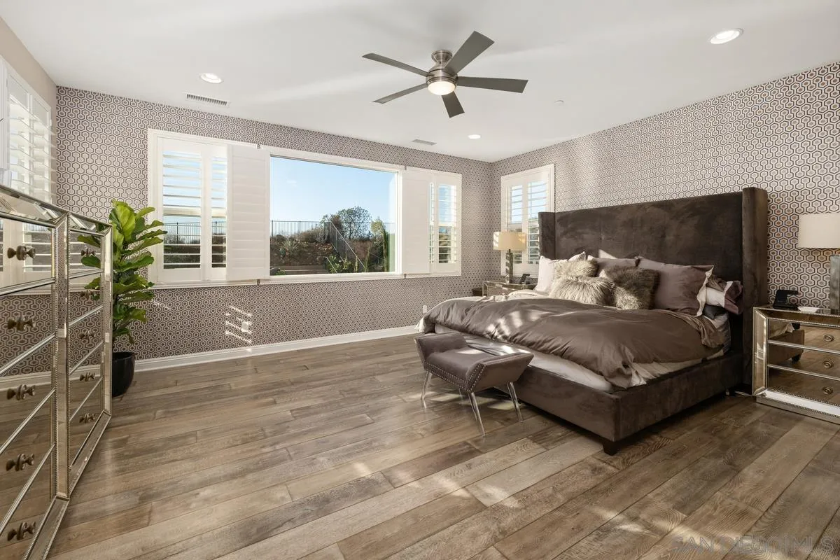 7495 Paseo Cristal Carlsbad, CA 92009 - Photo 36 of 75 a bedroom with a bed couch and a large window