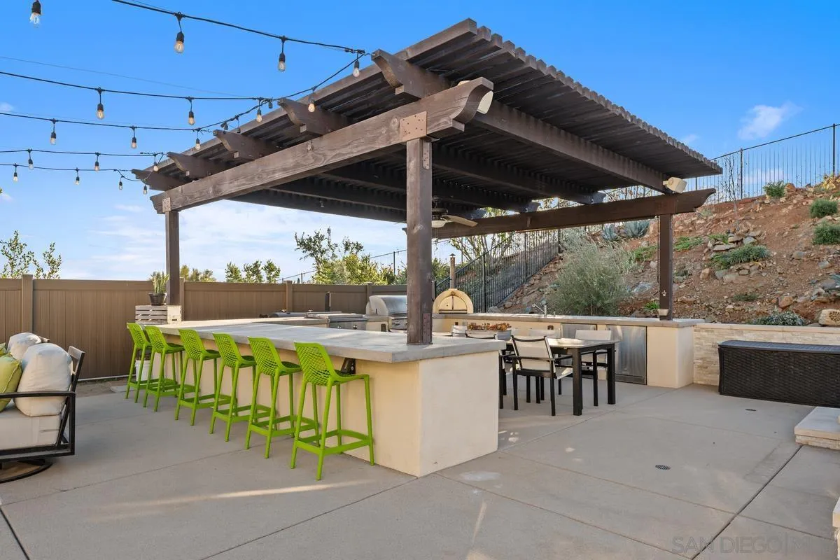 7495 Paseo Cristal Carlsbad, CA 92009 - Photo 55 of 75 a view of a patio with a table and chairs under an umbrella