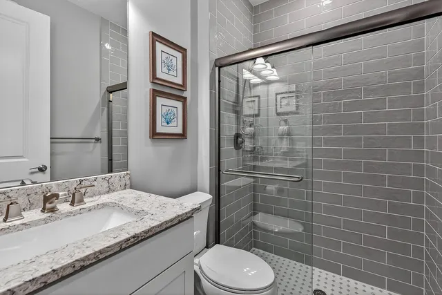 a bathroom with a granite countertop sink toilet and shower