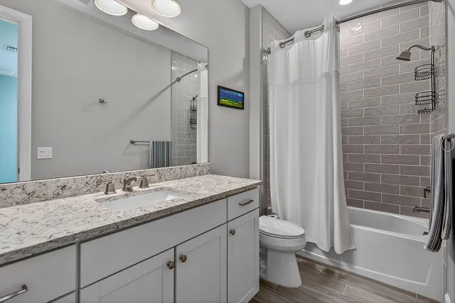 a bathroom with a granite countertop sink toilet and shower