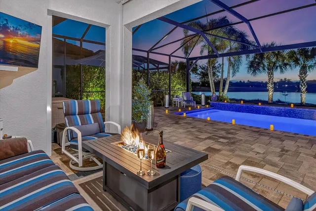 a living room with furniture a flat screen tv and floor to ceiling window