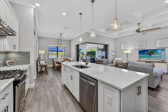 a kitchen with stainless steel appliances granite countertop a sink a stove and a wooden floors