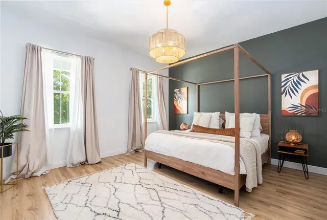 a bedroom with a bed and a chandelier