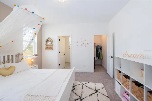 a bedroom with a bed and a large mirror on the dresser
