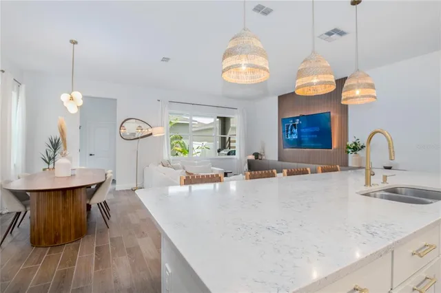 a large kitchen with granite countertop a sink a stove and a wooden floors