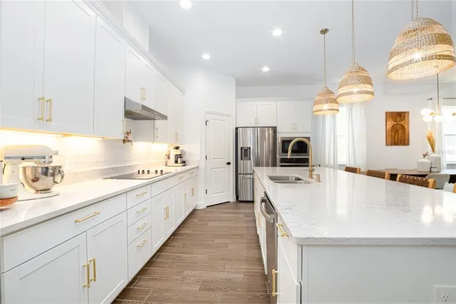 a large kitchen with kitchen island a sink stainless steel appliances and cabinets