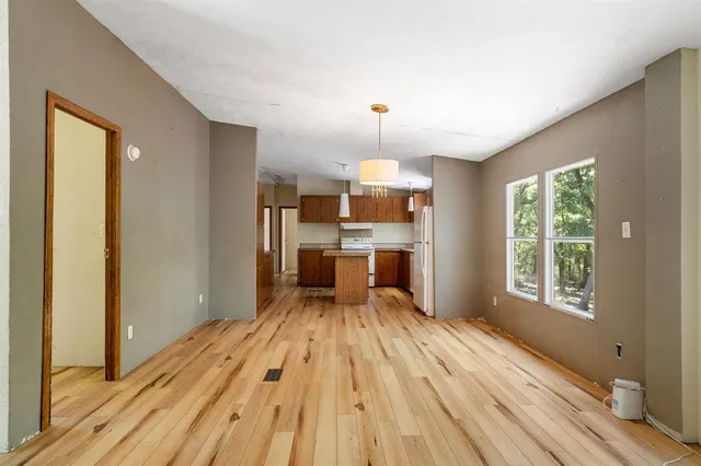 a view of a kitchen with wooden floor electronic appliances and windows