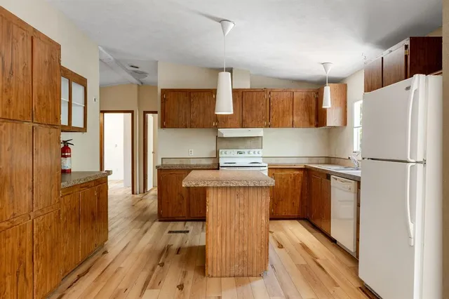 a kitchen with stainless steel appliances a refrigerator and a stove top oven
