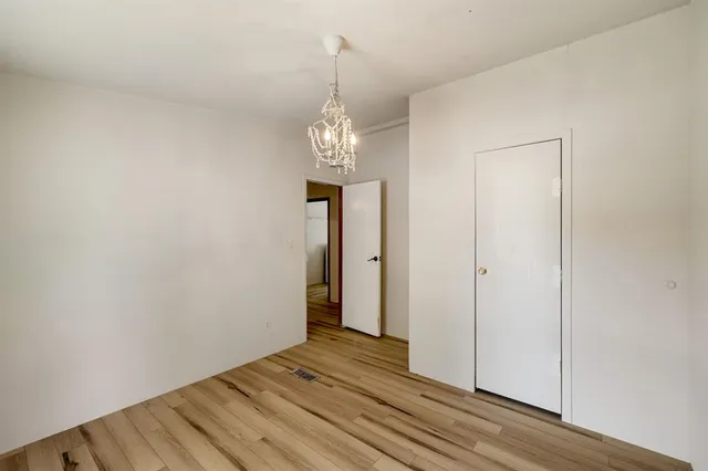 a view of a room with wooden floor and chandelier