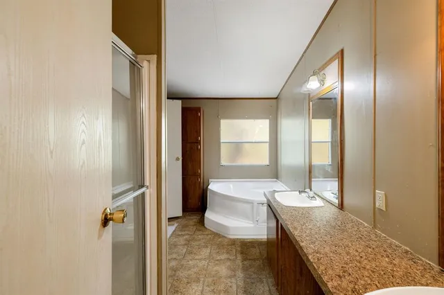 a spacious bathroom with a granite countertop sink and a mirror