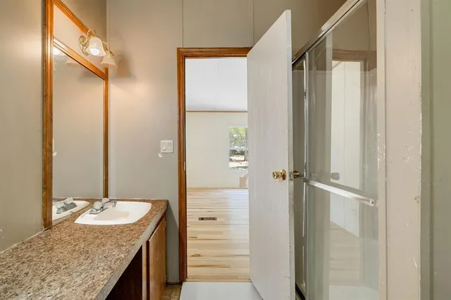 a bathroom with a granite countertop sink and a mirror
