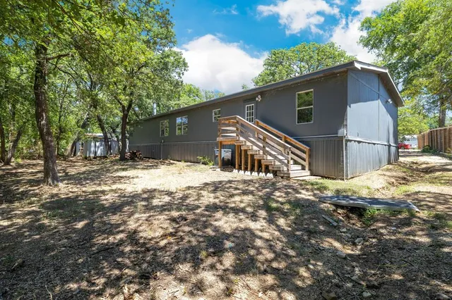 a backyard of a house with a large tree