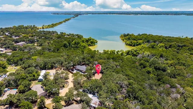an aerial view of a houses with a yard and lake view