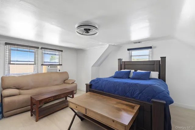 a bedroom with a bed couch and window