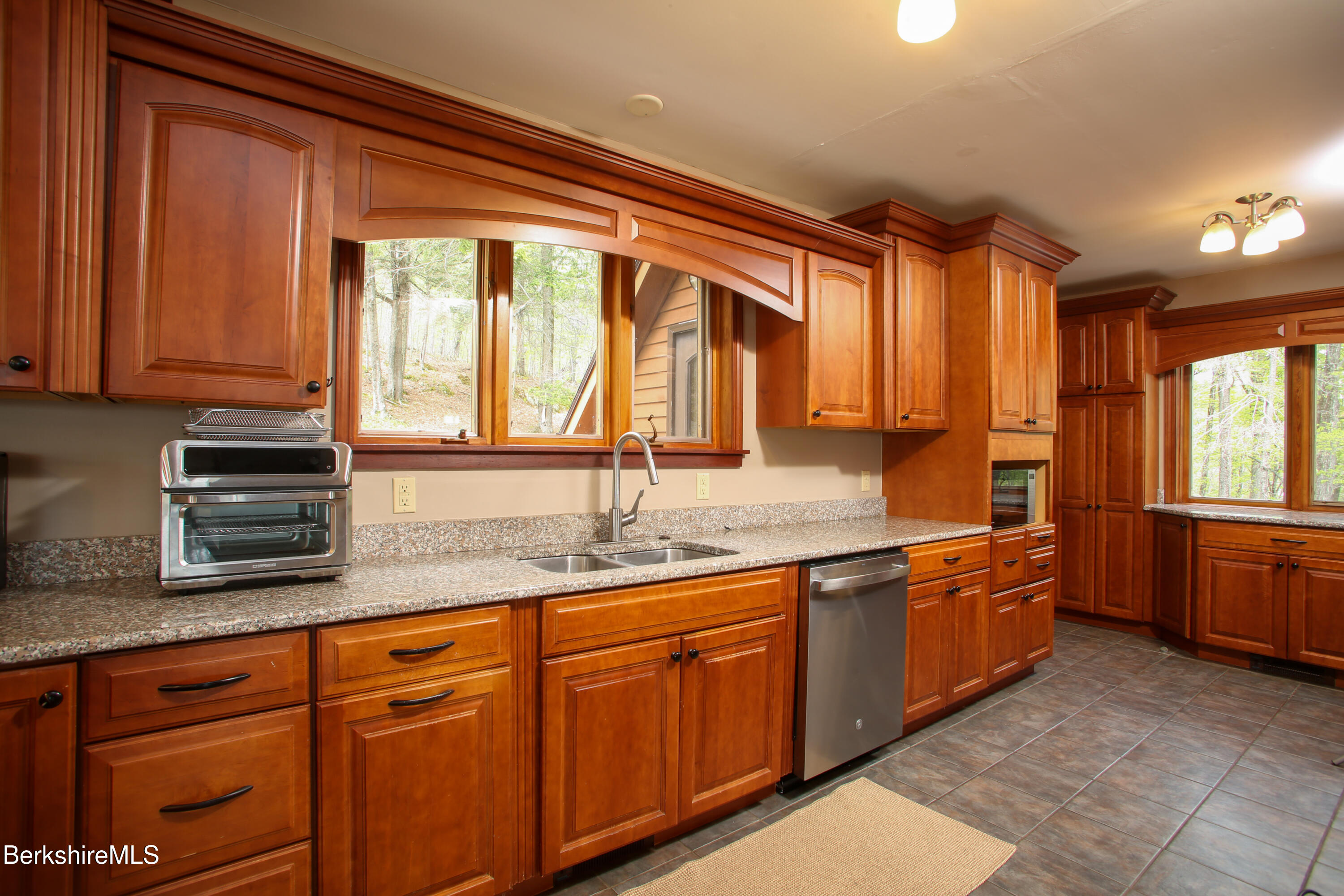 421 Legate Hill Road Charlemont, MA 01339 - Photo 11 of 37 a large kitchen with stainless steel appliances granite countertop a sink and dishwasher a stove with wooden cabinets