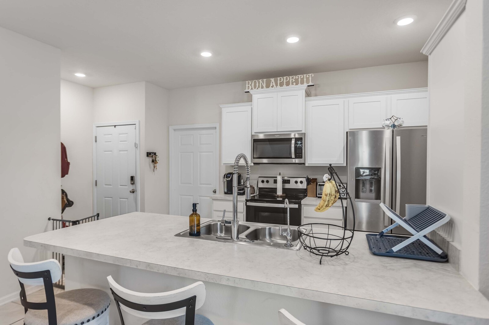 86784 Mainline Road Yulee, FL 32097 - Photo 5 of 25 a kitchen with stainless steel appliances a sink a stove a microwave a refrigerator and cabinets