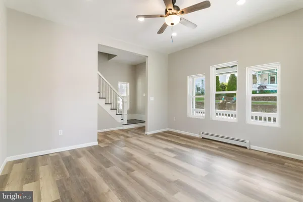 a view of an empty room with a window and wooden floor
