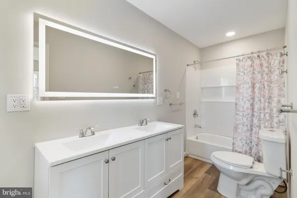 a bathroom with a sink toilet vanity and shower