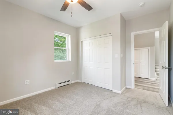 an empty room with a ceiling fan and a window