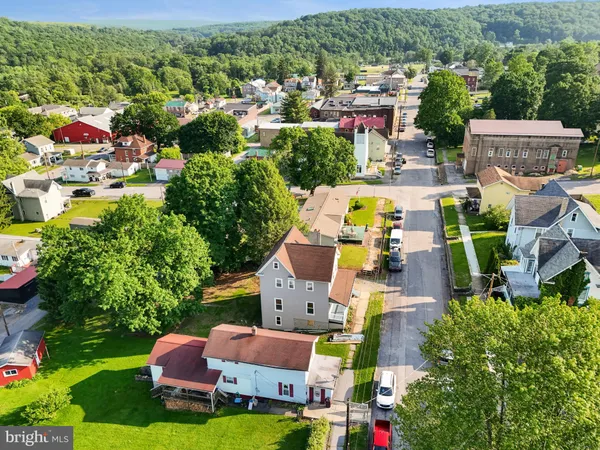 an aerial view of residential houses with outdoor space and parking