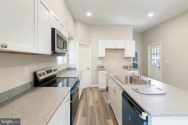 a kitchen with a sink a stove and cabinets