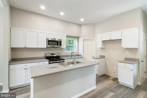 a kitchen with a sink a stove a microwave and cabinets