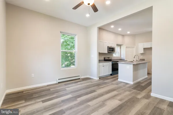 a view of kitchen with granite countertop cabinets and refrigerator