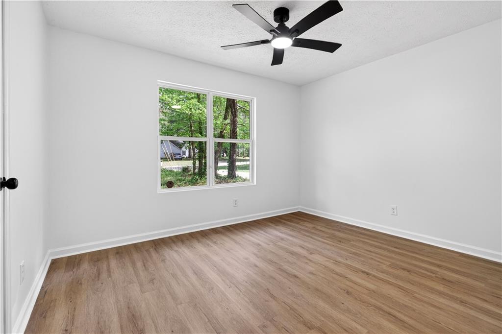 170 Kipling Way Riverdale, GA 30274 - Photo 10 of 16 an empty room with wooden floor chandelier fan and windows
