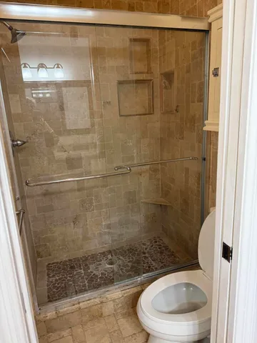 a bathroom with a granite countertop toilet a sink and a mirror