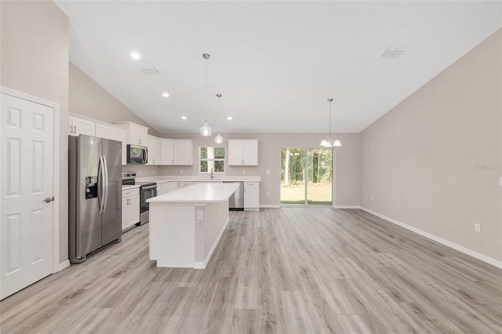 21010 Southwest 102nd Street Road Dunnellon, FL 34431 - Photo 11 of 47 a large kitchen with a wooden floor and stainless steel appliances