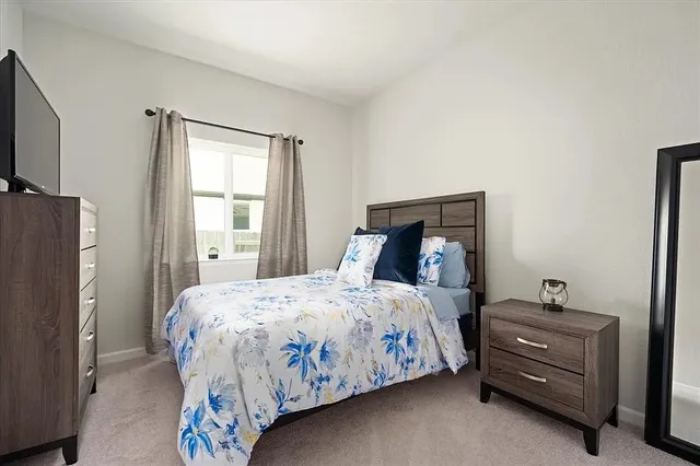 a bedroom with a bed and a potted plant