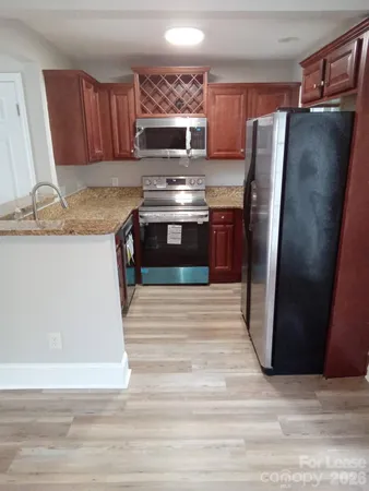 a kitchen with granite countertop a refrigerator and a stove