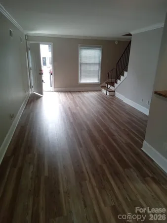 a view of a room with wooden floor and window