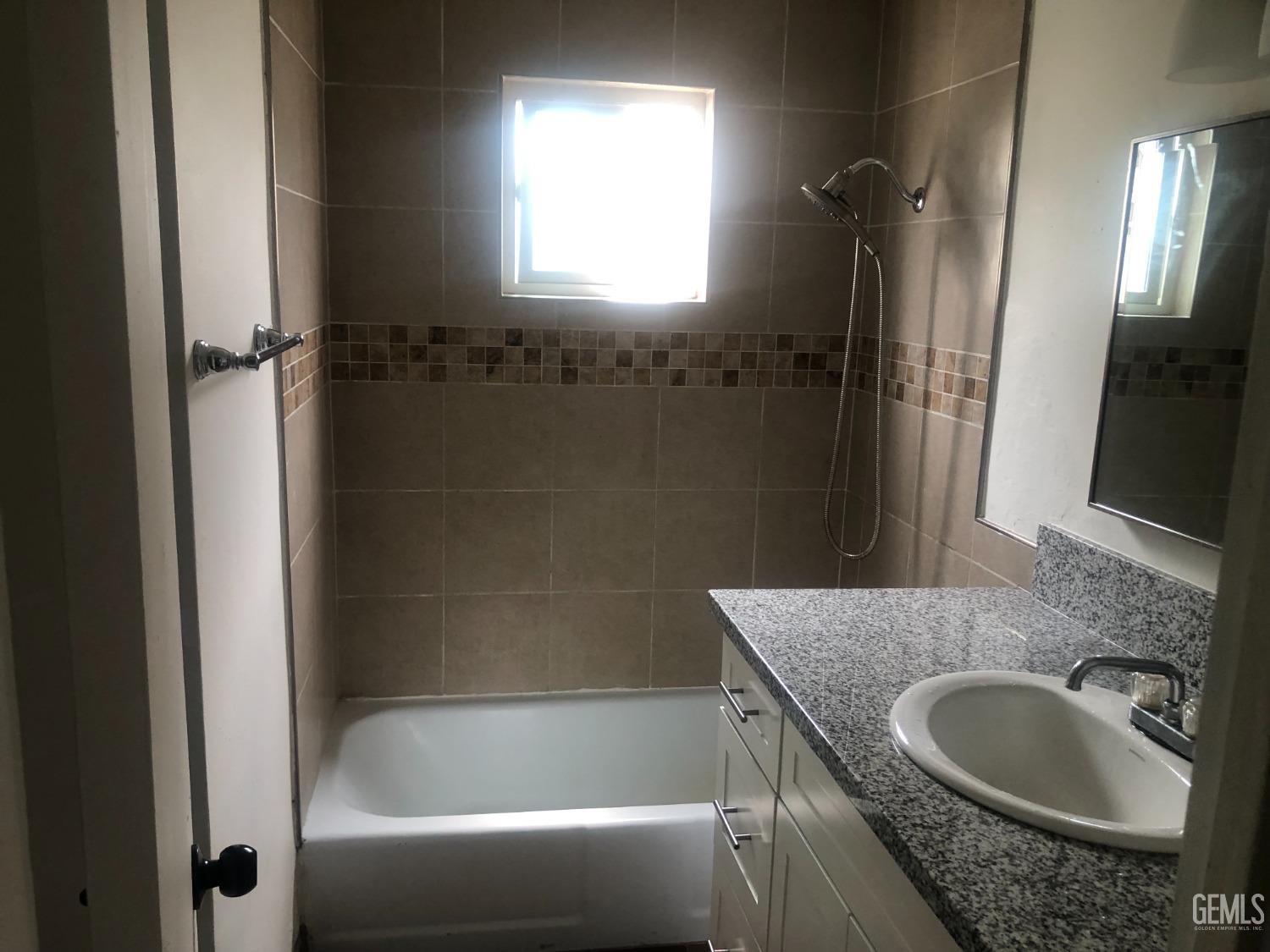 Undisclosed Address Bakersfield, CA 93308 - Photo 5 of 11 a bath room with a granite countertop sink and a mirror