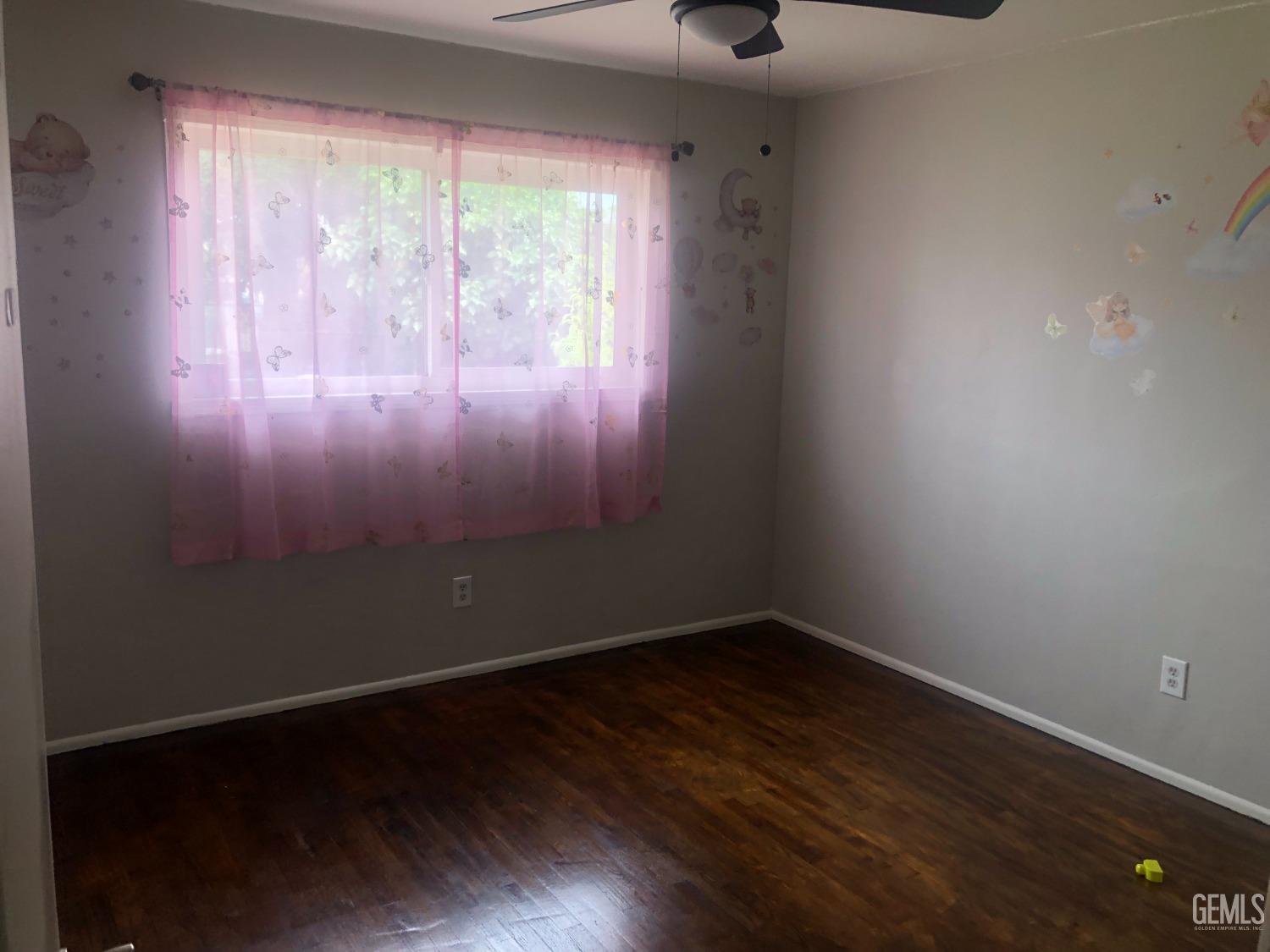 Undisclosed Address Bakersfield, CA 93308 - Photo 6 of 11 a view of an empty room with wooden floor and a window