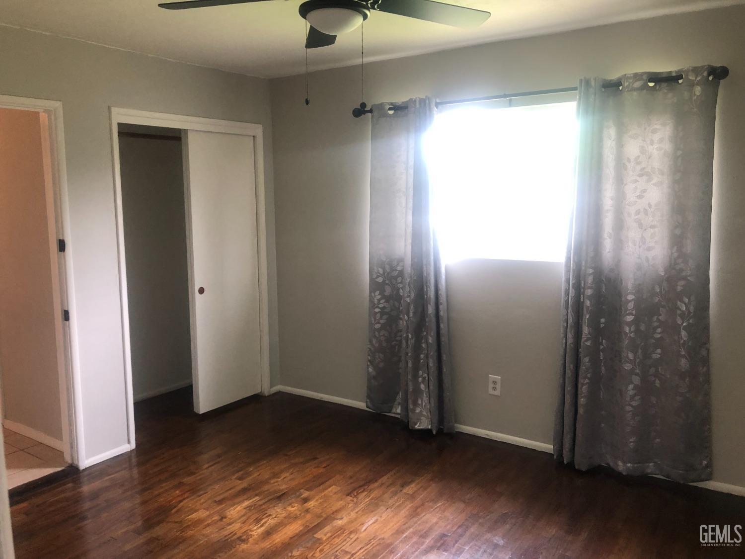 Undisclosed Address Bakersfield, CA 93308 - Photo 7 of 11 an empty room with wooden floor closet and windows