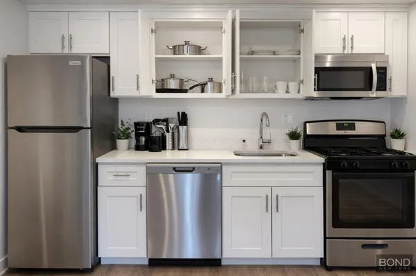 a kitchen with stainless steel appliances a refrigerator stove and microwave
