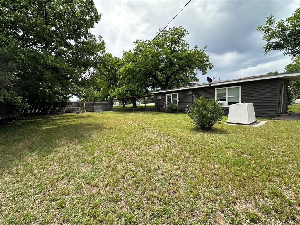 7350 Highway 67, Unit 377N Comanche, TX 76442 - Photo 9 of 13 a view of a backyard with table and chairs potted plants and large tree