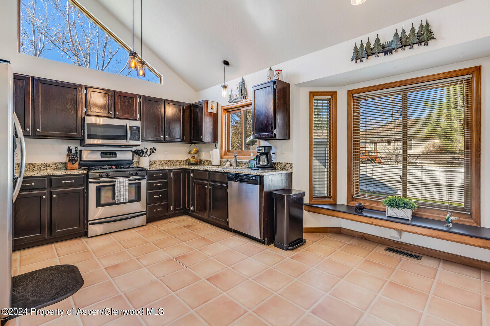 176 Rabbit Road Carbondale, CO 81623 - Photo 18 of 29 a kitchen with stainless steel appliances granite countertop a stove top oven a sink dishwasher a dining table and chairs