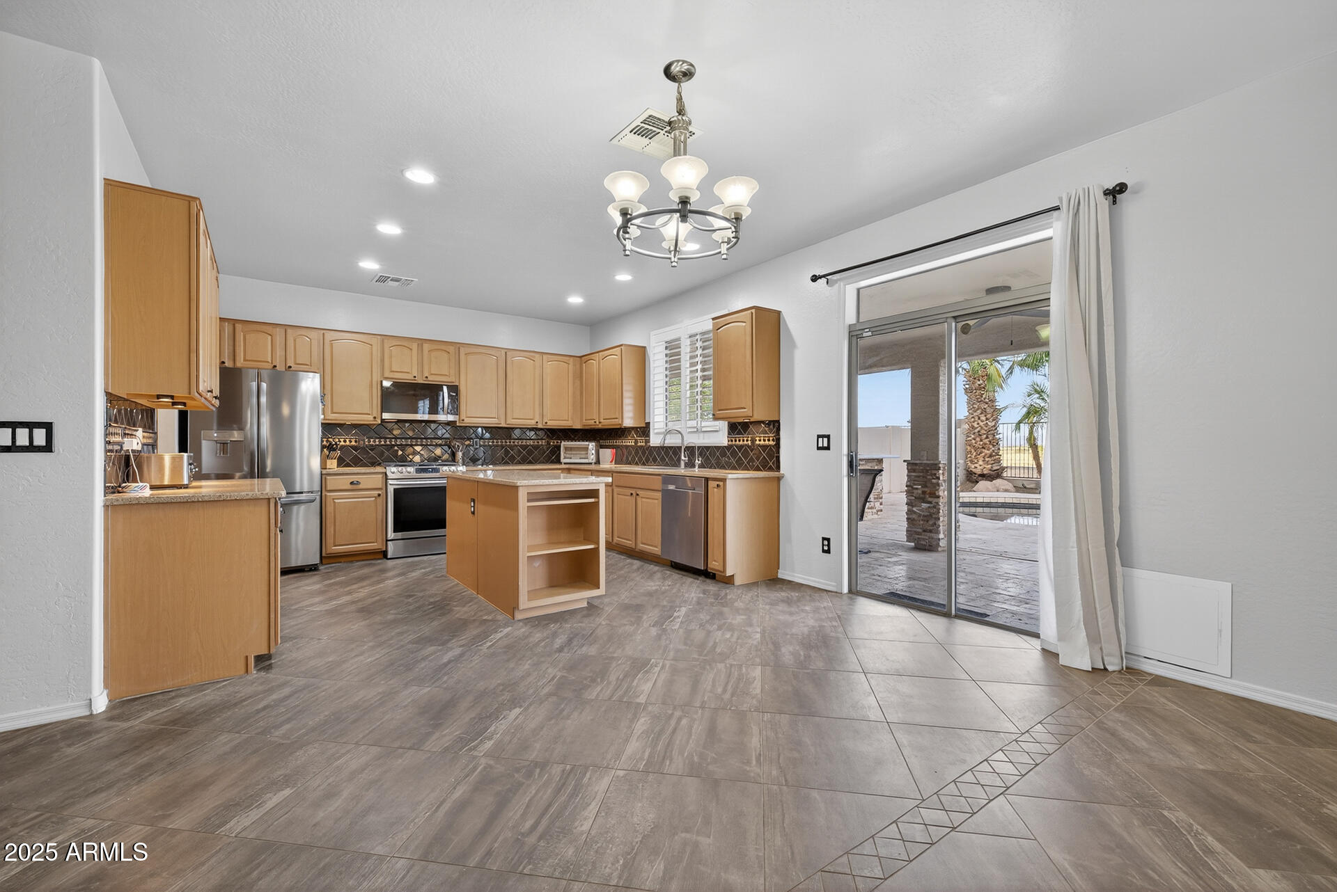 28305 North Desert Native Street San Tan Valley, AZ 85143 - Photo 20 of 81 a kitchen with a chandelier stainless steel appliances cabinets and a counter top space