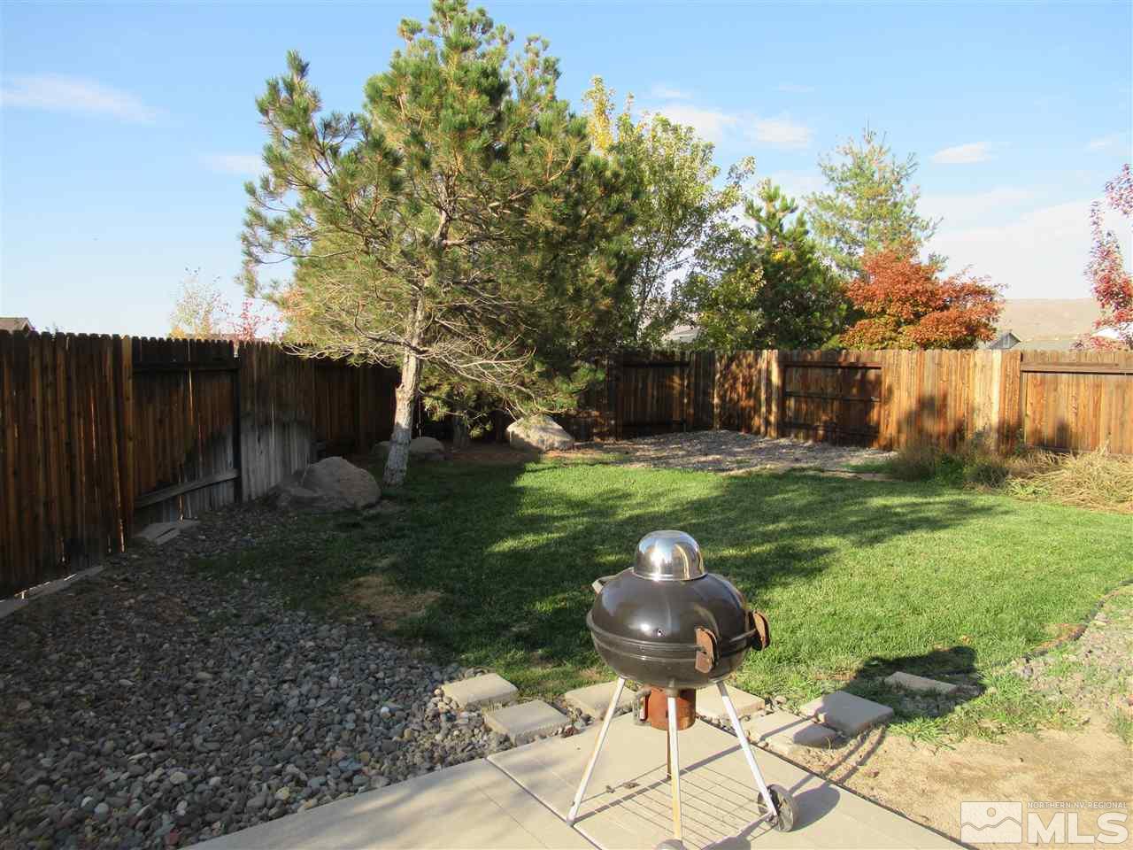 2347 Clementine Lane Reno, NV 89521 - Photo 17 of 19 a view of a backyard with table and chairs potted plants and wooden fence